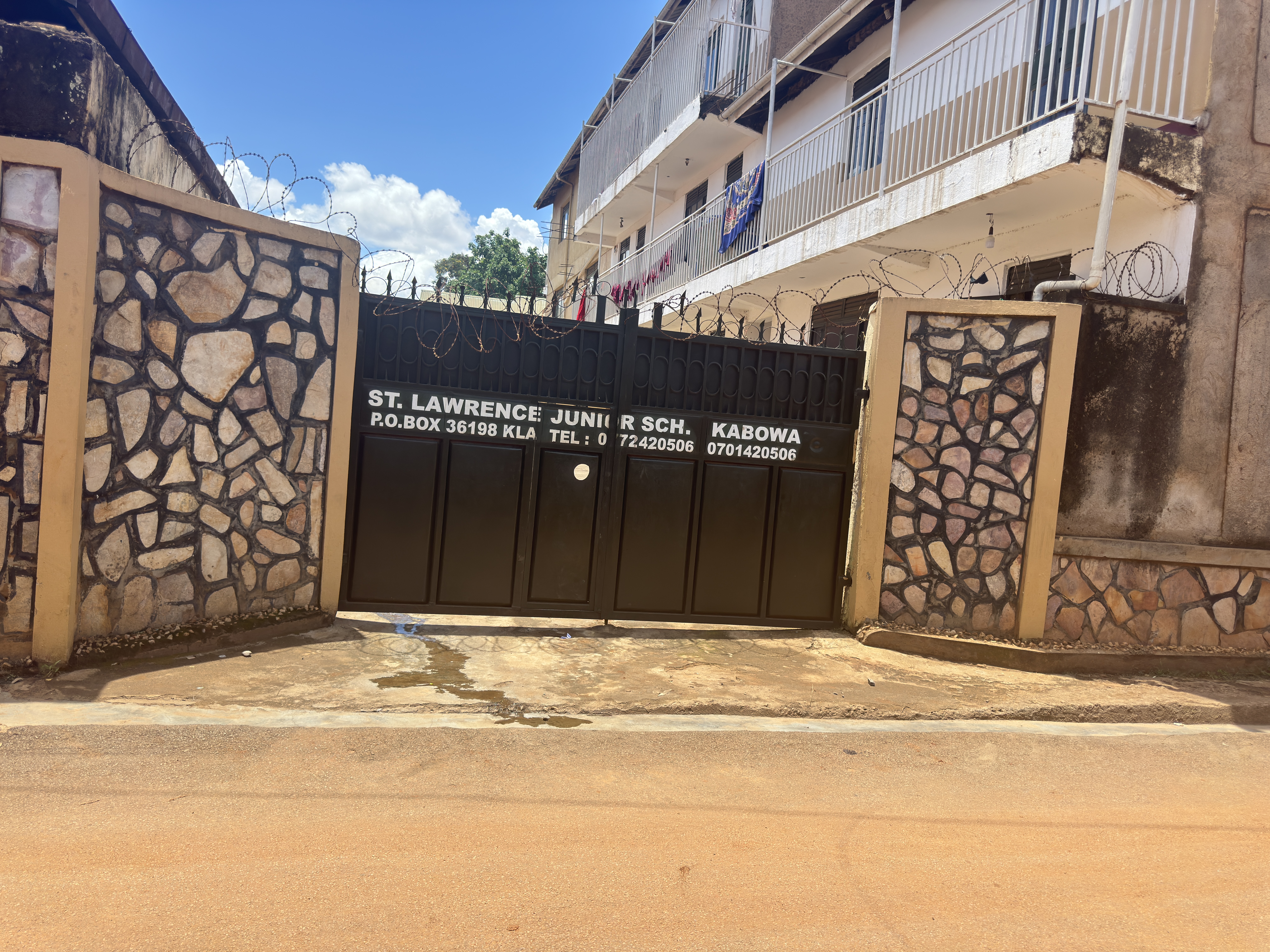 St. Lawrence Junior School Kabowa campus entrance showing official crest and school values on the perimeter wall